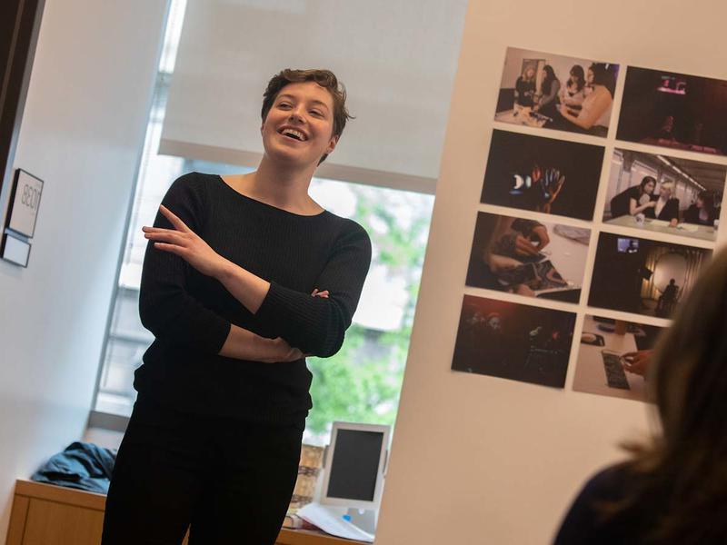 Young woman standing in an office, laughing