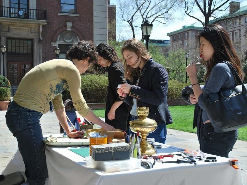 4 students around a table set up outside on a spring day