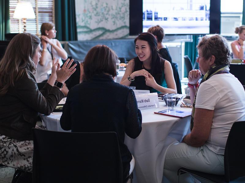 4 women sitting together at a table over lunch